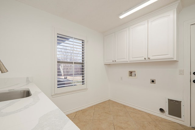 washroom with cabinet space, plenty of natural light, hookup for a washing machine, and light tile patterned floors