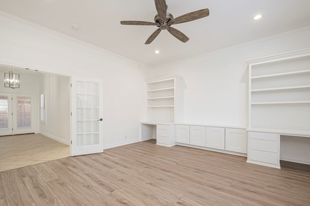 interior space with crown molding, built in desk, ceiling fan with notable chandelier, and light wood-style floors