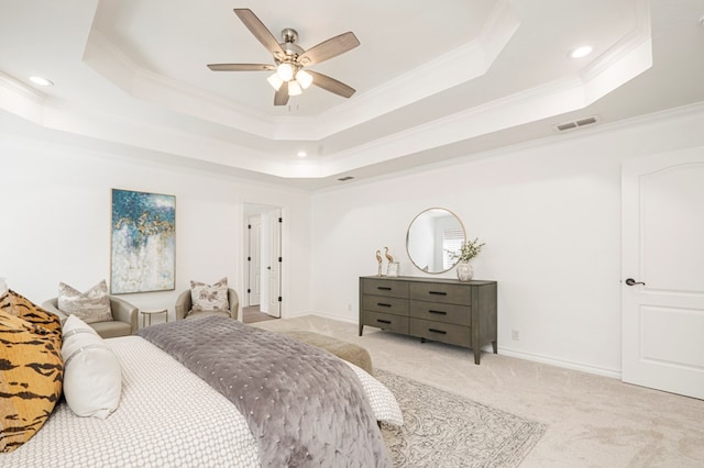 bedroom featuring crown molding, a tray ceiling, baseboards, and light colored carpet