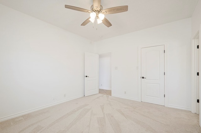 unfurnished room with baseboards, a ceiling fan, and light colored carpet