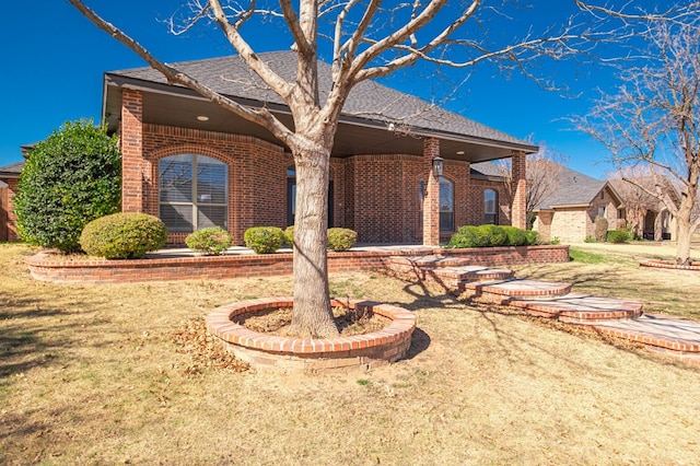 single story home featuring a front yard and brick siding