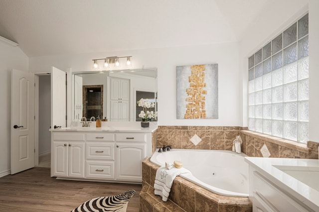 bathroom with vanity, a whirlpool tub, and wood finished floors