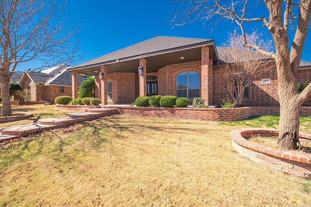 ranch-style home with a front lawn and brick siding