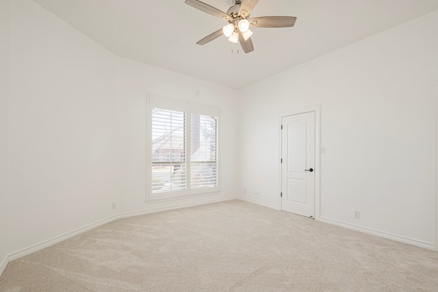 empty room featuring light colored carpet, ceiling fan, and baseboards