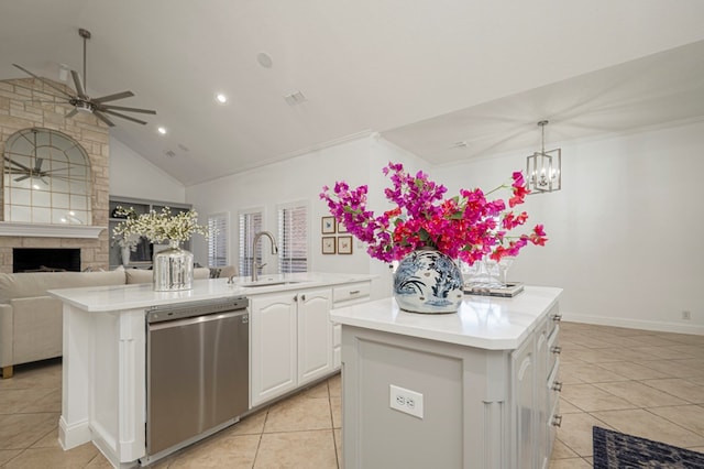 kitchen featuring light countertops, stainless steel dishwasher, a sink, and a kitchen island with sink