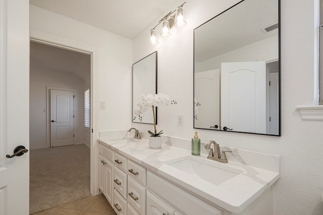 bathroom with tile patterned floors, visible vents, a sink, and double vanity