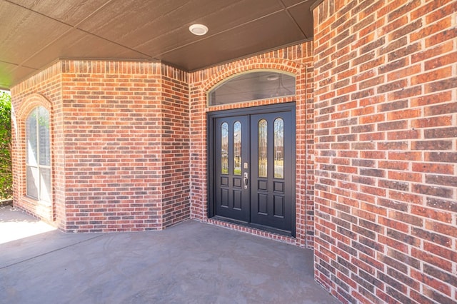 doorway to property featuring brick siding and french doors