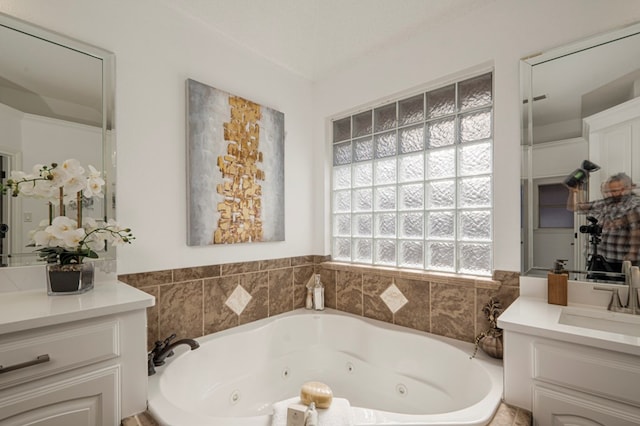 full bathroom with a jetted tub and vanity