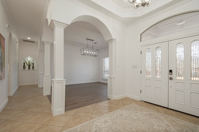 entrance foyer with light tile patterned flooring, visible vents, baseboards, decorative columns, and crown molding