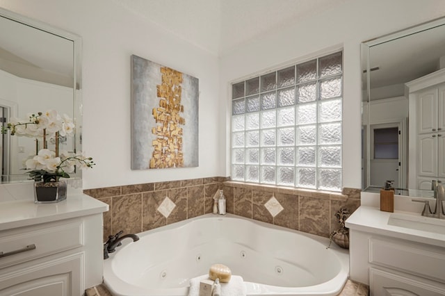 bathroom with a jetted tub and vanity