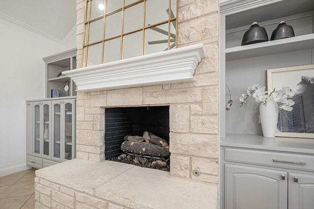 details featuring crown molding, a stone fireplace, and baseboards