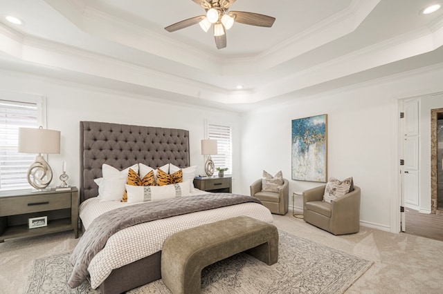 bedroom featuring a ceiling fan, a raised ceiling, light colored carpet, and crown molding