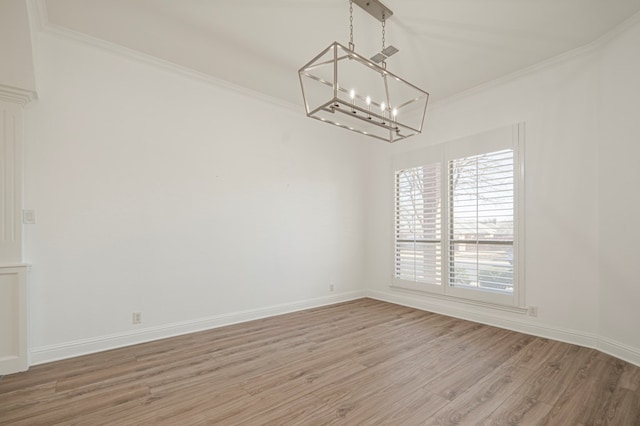 empty room with baseboards, an inviting chandelier, wood finished floors, and crown molding