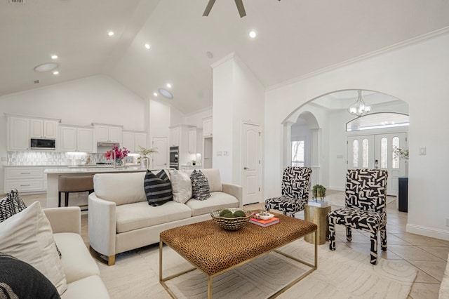 living area with arched walkways, french doors, a ceiling fan, light tile patterned flooring, and high vaulted ceiling