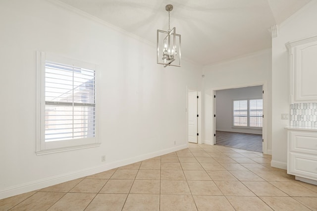 unfurnished dining area with light tile patterned floors, baseboards, ornamental molding, and a notable chandelier