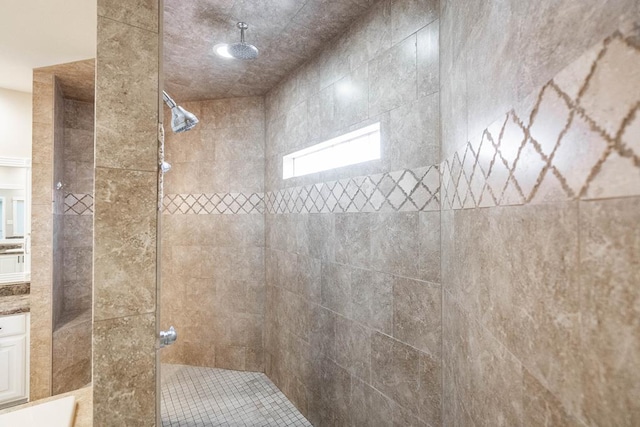 bathroom featuring a tile shower and vanity