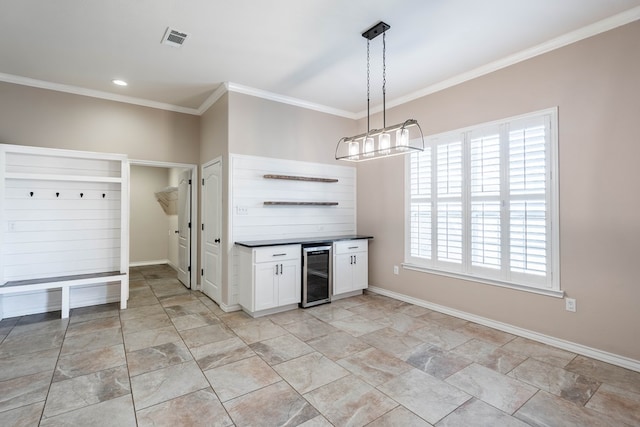 kitchen featuring white cabinets, beverage cooler, a healthy amount of sunlight, and hanging light fixtures