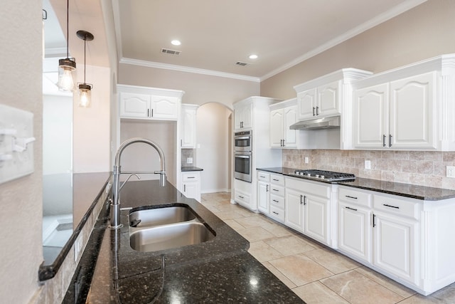 kitchen featuring dark stone countertops, sink, white cabinetry, decorative light fixtures, and tasteful backsplash