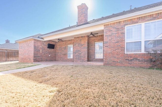 rear view of property with a patio, ceiling fan, and a lawn