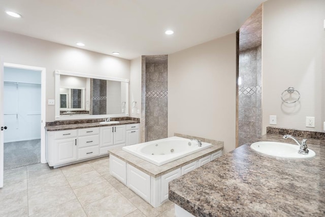 bathroom featuring vanity, tile patterned floors, and a tub to relax in