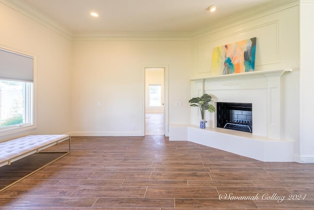 unfurnished living room featuring ornamental molding and hardwood / wood-style flooring