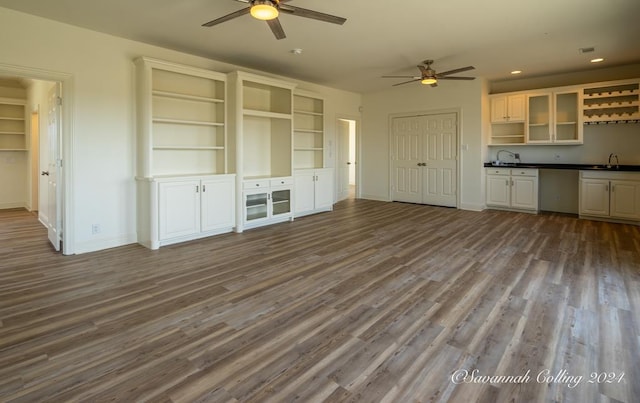 unfurnished living room with ceiling fan, light hardwood / wood-style floors, and sink