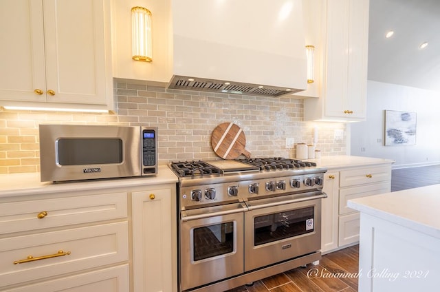 kitchen featuring white cabinetry, wall chimney exhaust hood, stainless steel appliances, tasteful backsplash, and dark hardwood / wood-style floors