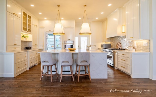 kitchen featuring white cabinetry, dark hardwood / wood-style flooring, a kitchen island with sink, and appliances with stainless steel finishes