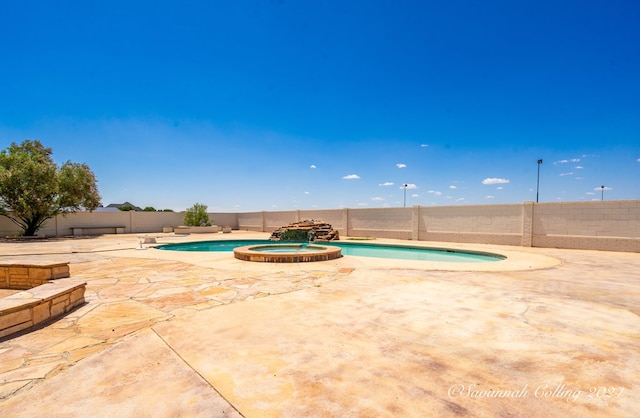 view of swimming pool featuring an in ground hot tub and a patio area