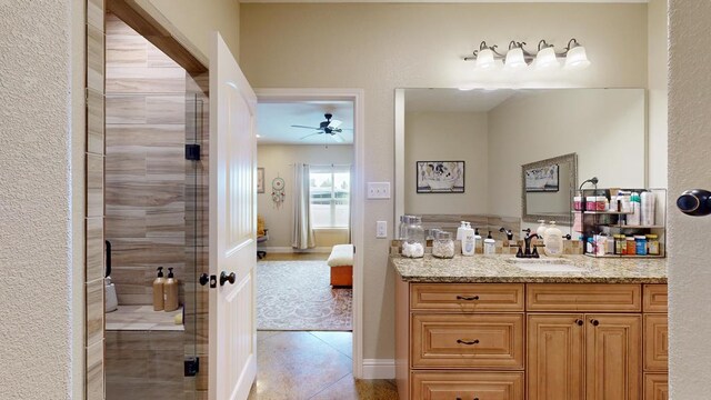 ensuite bathroom with vanity, ensuite bathroom, a ceiling fan, and tiled shower
