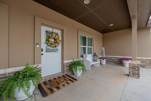 entrance to property with brick siding and a porch