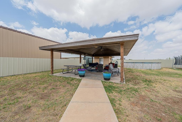 view of yard featuring a gazebo, a pool, a patio, and ceiling fan