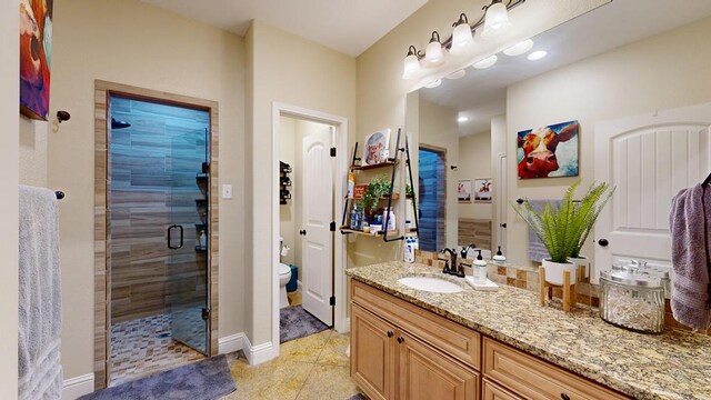 full bathroom with a shower stall, baseboards, toilet, tile patterned floors, and vanity
