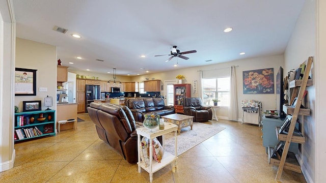 living area with ceiling fan, visible vents, baseboards, recessed lighting, and light speckled floor