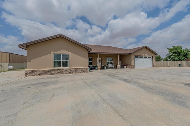 single story home with stucco siding, fence, driveway, and a garage
