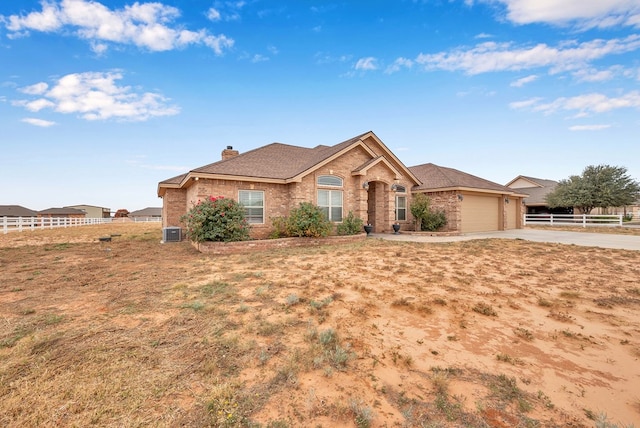 ranch-style house featuring central AC and a garage