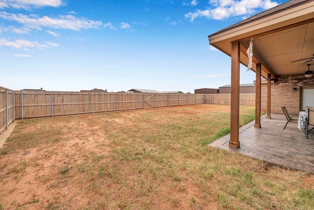 view of yard featuring ceiling fan and a patio