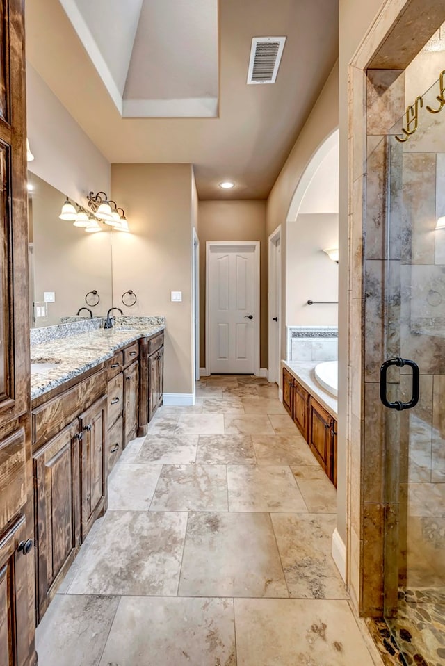 bathroom with vanity and separate shower and tub