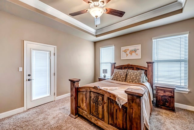 bedroom with crown molding, a tray ceiling, light colored carpet, and ceiling fan