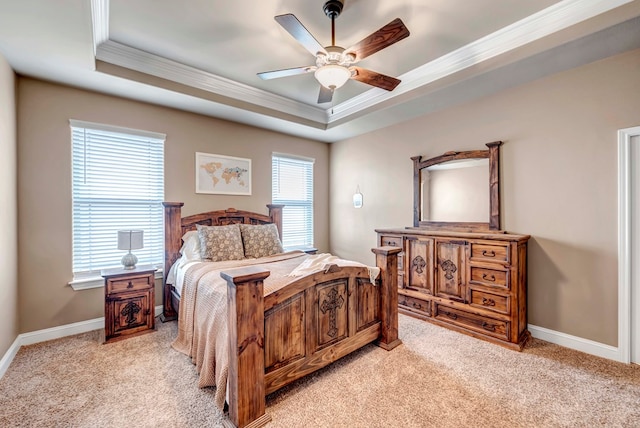 carpeted bedroom with ornamental molding, a raised ceiling, and ceiling fan