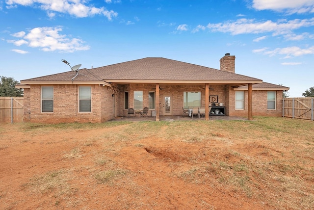 back of property featuring a yard and a patio area