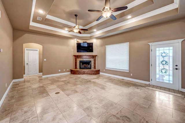 unfurnished living room with crown molding, ceiling fan, and a raised ceiling