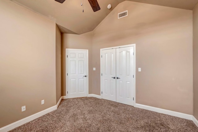 unfurnished bedroom featuring high vaulted ceiling, a closet, ceiling fan, and carpet