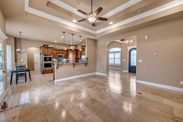 unfurnished living room with crown molding, a tray ceiling, and ceiling fan with notable chandelier