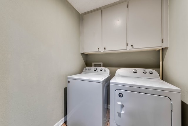 laundry area featuring cabinet space, independent washer and dryer, and baseboards