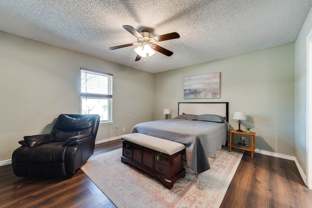 bedroom featuring ceiling fan, a textured ceiling, baseboards, and wood finished floors