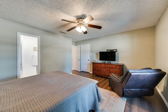 bedroom with a textured ceiling, wood finished floors, visible vents, and a ceiling fan