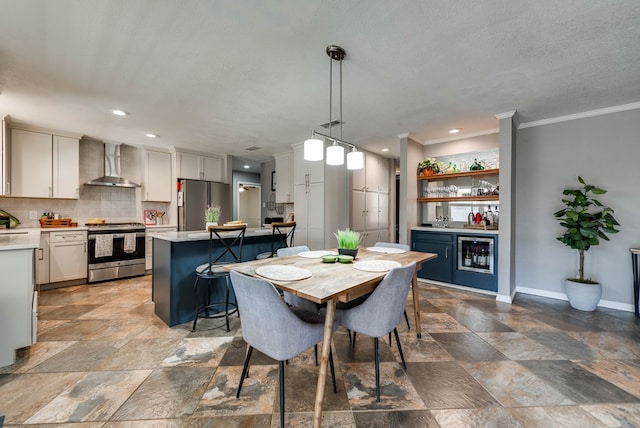 dining area featuring beverage cooler, baseboards, ornamental molding, stone finish flooring, and a dry bar