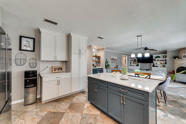 kitchen with white cabinetry, visible vents, light countertops, and freestanding refrigerator