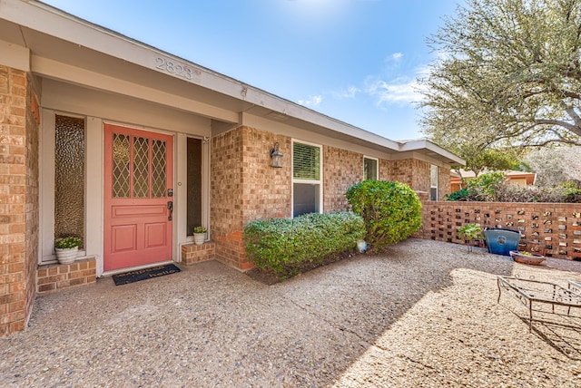 view of exterior entry with brick siding